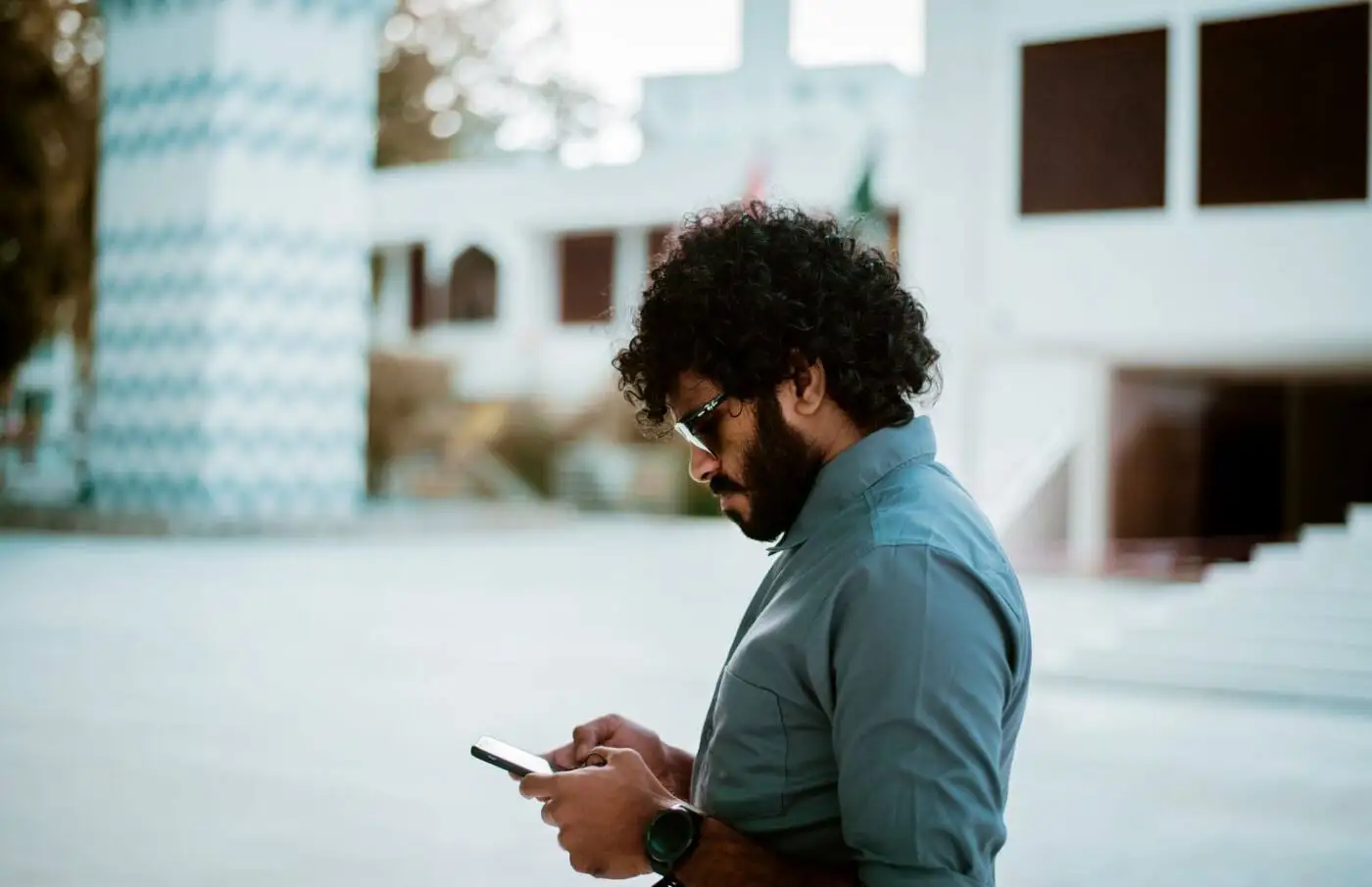 Man standing outside checking his loan options on his phone
