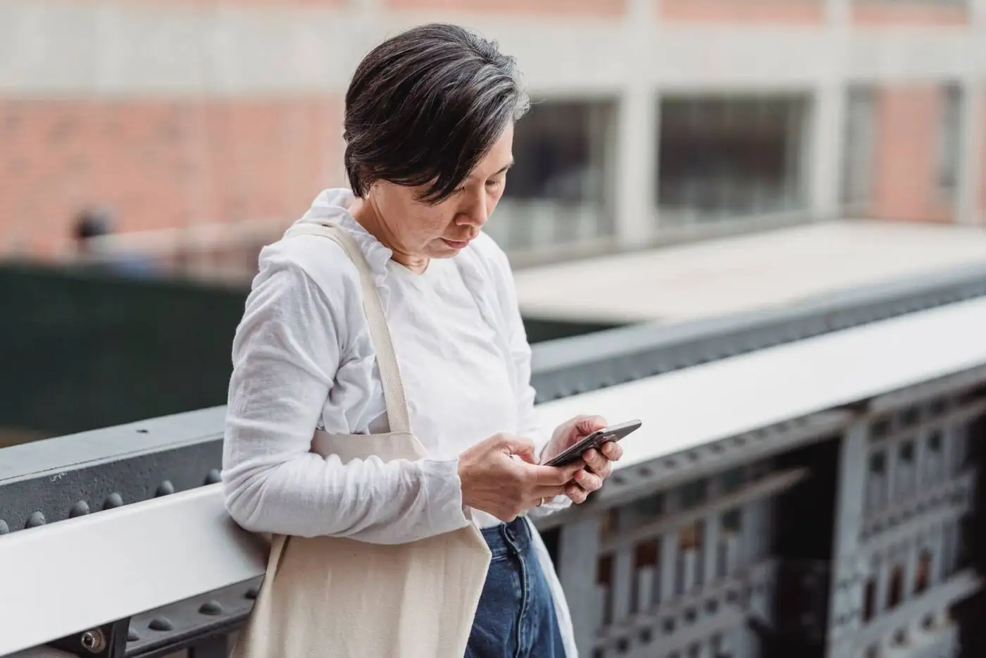 Woman checking her phone outdoors while applying for a payday loan