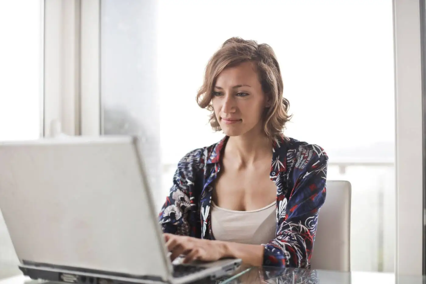 Woman at home on her laptop reviewing a personal loan